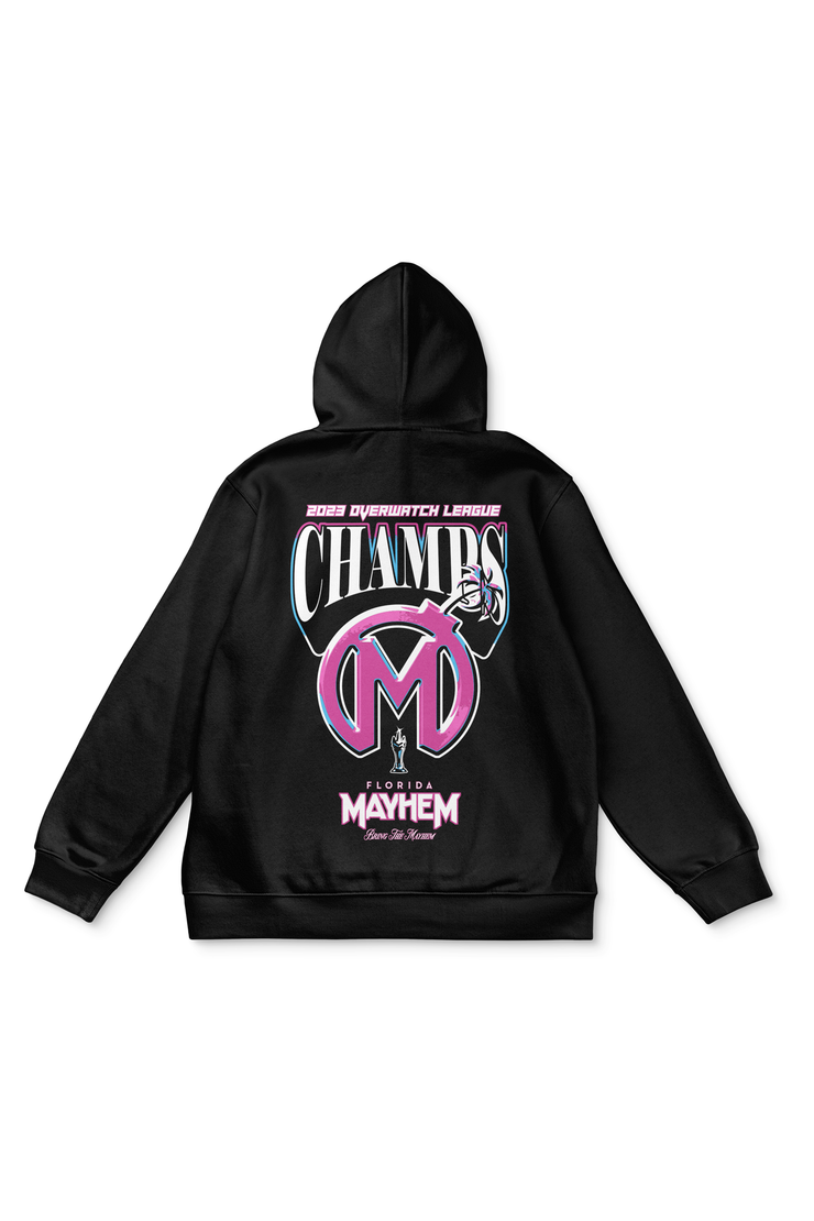 A black hoodie with the text "2022 Overwatch League CHAMPS" printed in bold pink and blue letters on the back. Below the text is a large circular logo with the initials "FM" in stylized font, representing the "Florida Mayhem" team. At the bottom, there&