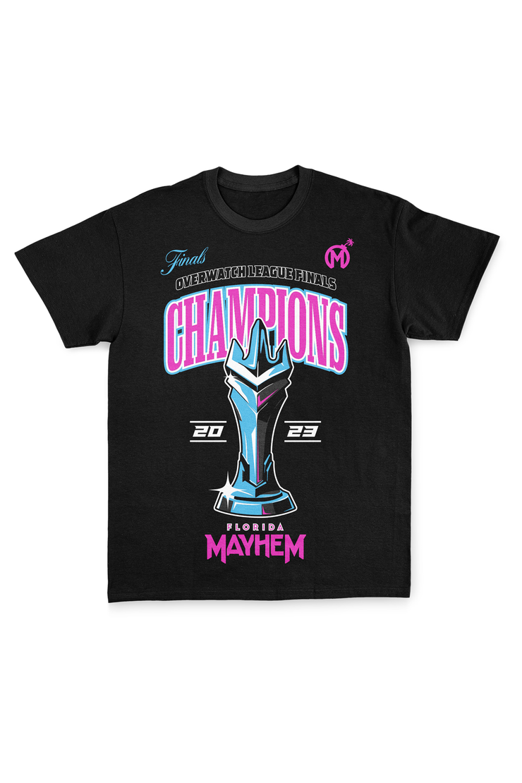 A black short-sleeved t-shirt featuring vibrant graphics. At the top, the word "Finals" in cyan is paired with "Overwatch League Finals" in pink. Below, the word "CHAMPIONS" is boldly displayed in pink, with a detailed blue and cyan trophy design beneath. The year 2023 flank the trophy, emphasizing the championship year. The phrase "Florida Mayhem" is written in bright pink at the bottom, with the team&