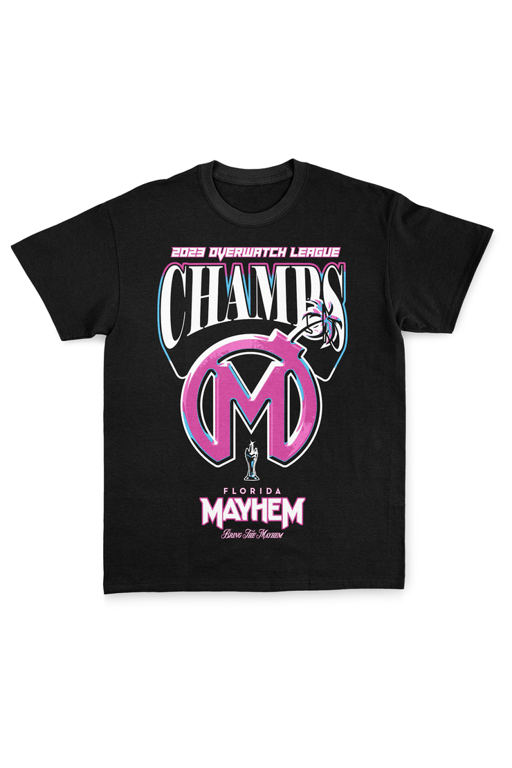 A black short-sleeved t-shirt displaying a vibrant design. The graphic prominently features "2023 Overwatch League CHAMPS" in pink, black, and cyan colors. Below, a large Florida Mayhem logo in pink and black, styled like a bomb, is centered. The words "Florida Mayhem" are written in bright pink font beneath the logo, with a small mascot icon just above the bottom hem.