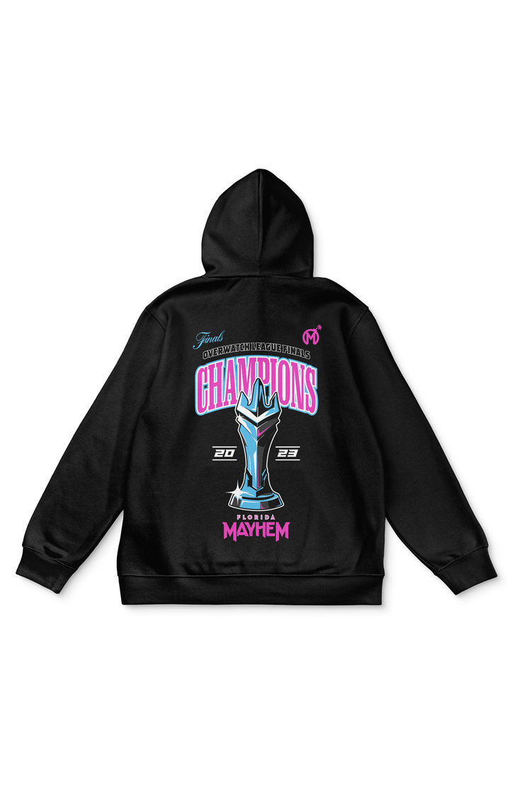 A black pullover hoodie with a design celebrating the "Finals Overwatch League Finals." It features the word "CHAMPIONS," a blue and teal trophy illustration, and the years 2023 At the bottom, "Florida Mayhem" is printed in pink with the team&